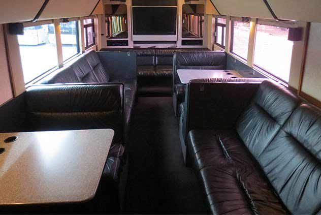 Windstar VIP Motorcoach Interior with leather couches, tables, and tv