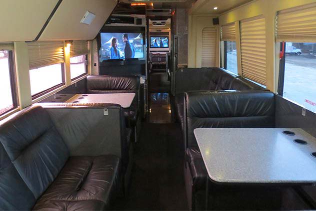 View of Windstar Bus Interior with leather seating, tables,and TV