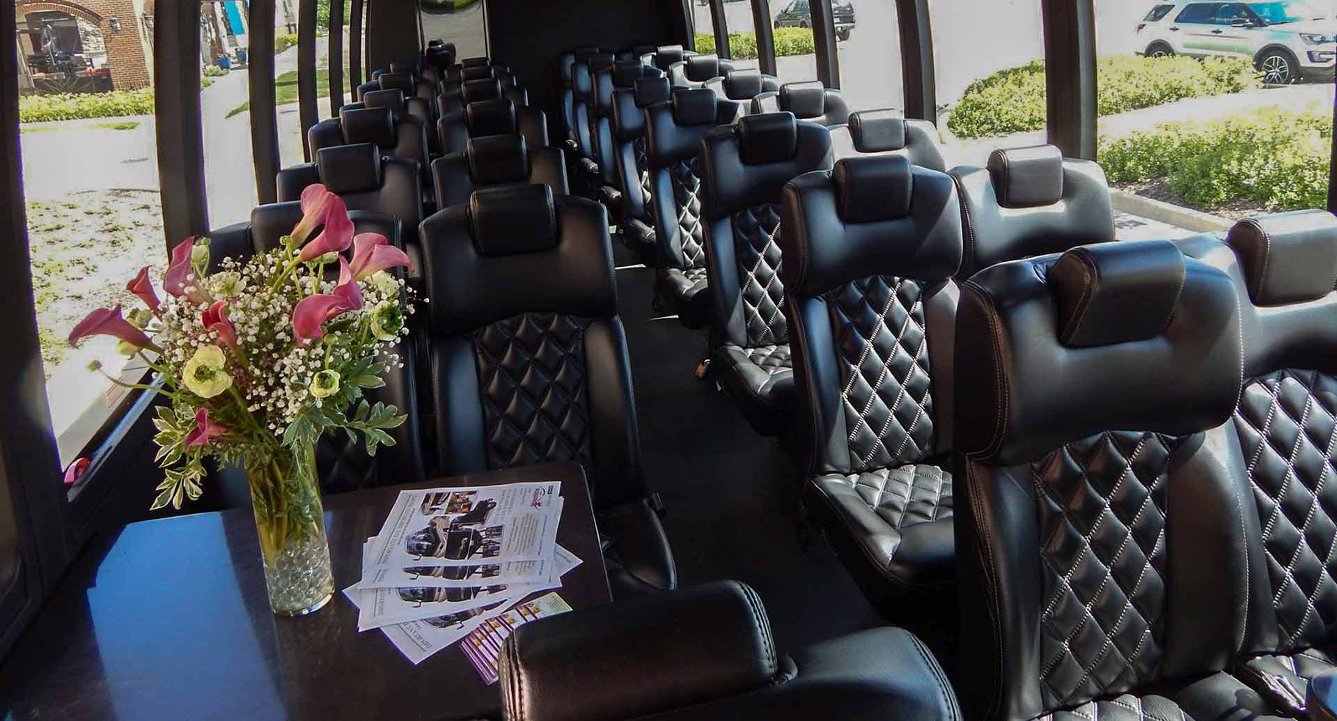 Charter Bus leather seats with a table and flowers