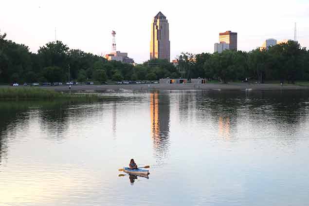 Person in a boat on a lake with a cityscape in background