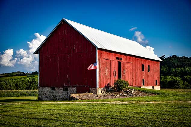 Red Barn near a field with an American flag in front