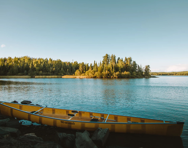 Canoe resting on rocks near a lake in Minnesota-Trees in distance